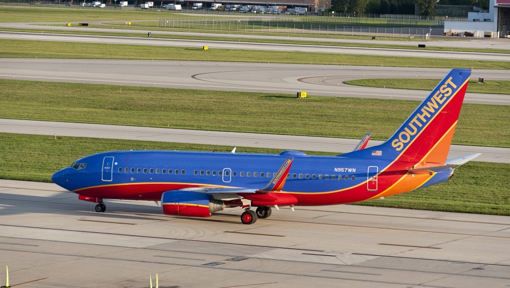 Southwest Icon Lounges: A Southwest Boeing 737-700 with the Tail number N957WN, preparing to take off on an August evening from KCMH.